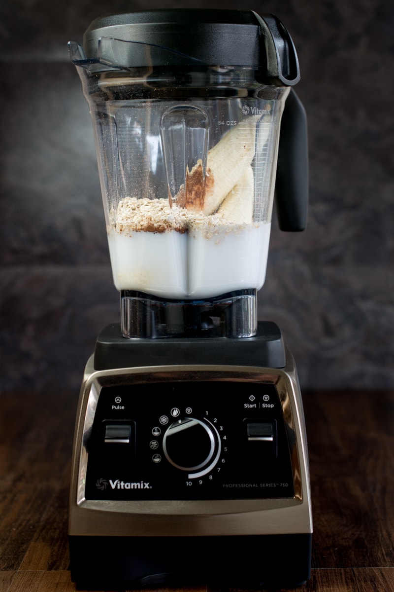 My Vitamix 750 filled with banana, cocoa powder, oats, vanilla extract and coconut milk, ready to make a delicious coconut, banana and chocolate smoothie.