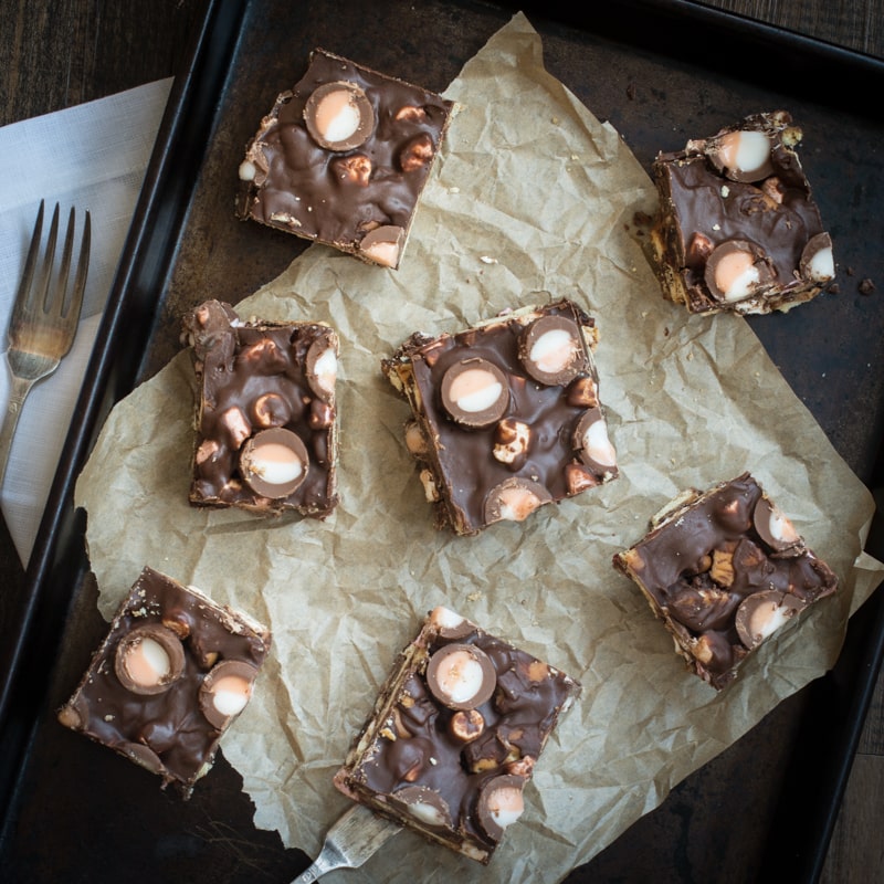 Looking down on some squares of Creme Egg Rocky Road with a fork at the side.