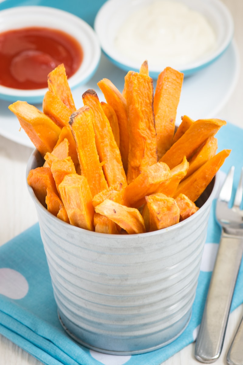 Cooked fries served in a silver container with the fries all on their end and poking out the top. 