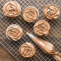 Looking down on some Nutella cupcakes topped with Nutella buttercream and a piping bag full of Nutella buttercream.