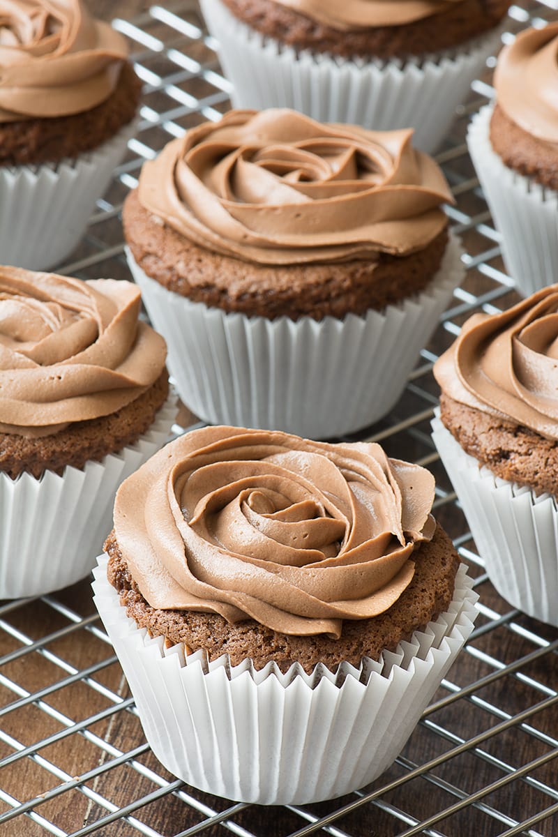 Nutella cupcakes topped with Nutella buttercream on a cooling rack.