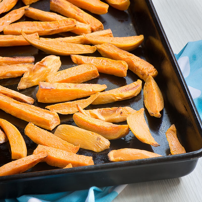 Cooked sweet potatoes fries on an oven tray. 