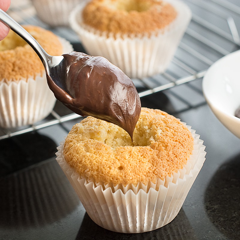 White Russian Cupcakes inspired by the classic cocktail - Baileys whipped cream sponge, topped with a White Russian buttercream and a hidden dark chocolate and vodka ganache centre.