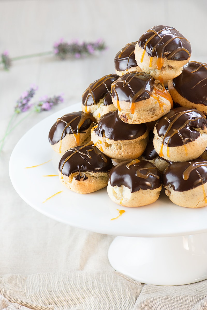Double chocolate and caramel profiteroles - crisp choux pastry filled with milk chocolate mousse and topped with dark chocolate sauce and caramel.