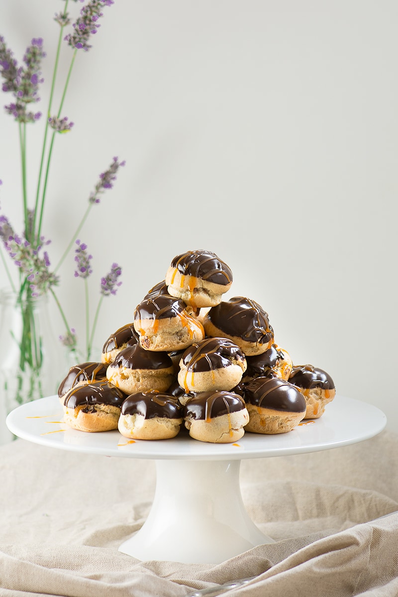 Double chocolate and caramel profiteroles - crisp choux pastry filled with milk chocolate mousse and topped with dark chocolate sauce and caramel.