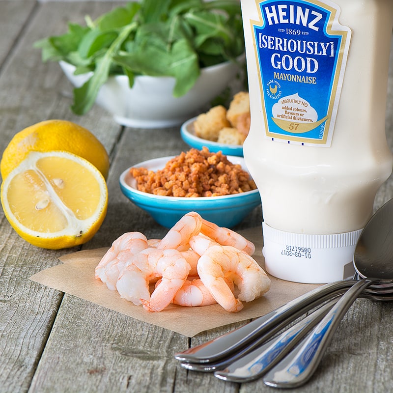 Fresh king prawns with rocket, croutons, bacon, lemon and mayonnaise, all served on a single spoon - perfect for a party.