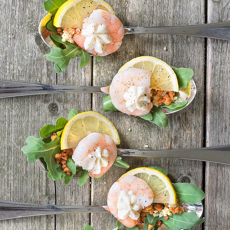 Fresh king prawns with rocket, croutons, bacon, lemon and mayonnaise, all served on a single spoon - perfect for a party.