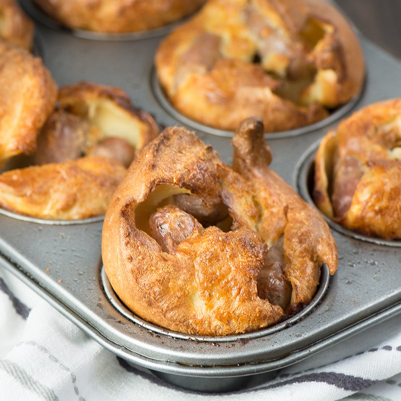 Mini toad-in-the hole - A delicious twist on my classic Yorkshire pudding recipe with a chipolata sausage hiding in each one. The perfect size for your little ones and grown-ups will love them too.