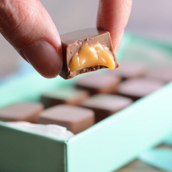 chocolatier pouring caramel filling into chocolate mold preparing handmade  candy Stock Photo - Alamy