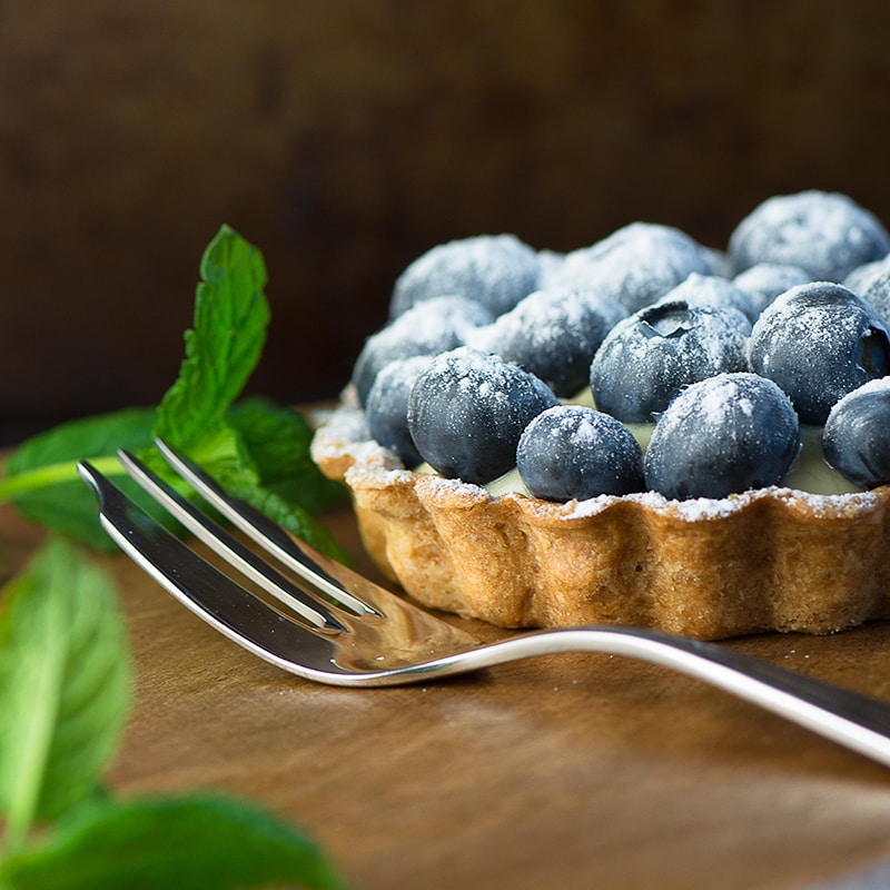 Summer berry and custard tarts - crispy pastry filled with creamy vanilla custard and topped with fresh, juicy berries. A delicious, elegant summer dessert.