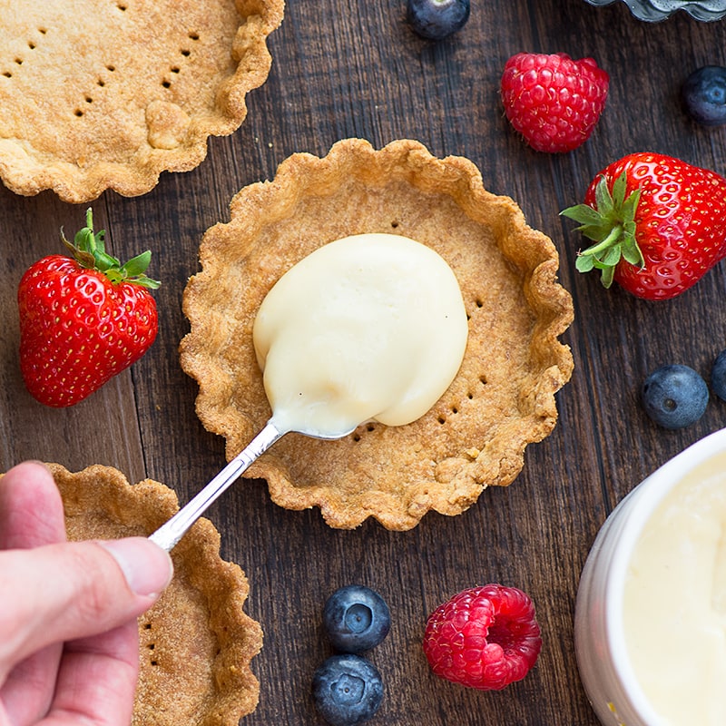 Summer berry and custard tarts - crispy pastry filled with creamy vanilla custard and topped with fresh, juicy berries. A delicious, elegant summer dessert.