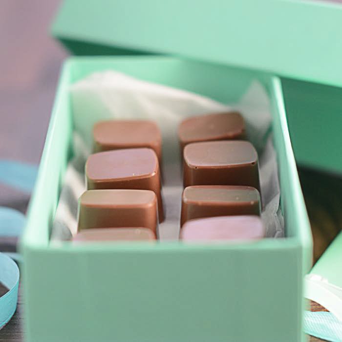 Closeup of squeezing filling of salted caramel cream from confectionery bag  into candy molds for preparing handmade chocolate pralines Stock Photo -  Alamy