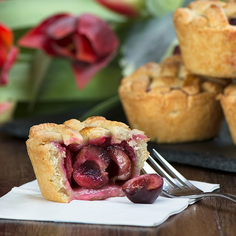 Homemade cherry pies with a pretty lattice top - crisp almond pastry, filled with juicy cherries. Perfect for a summer picnic or with a scoop of icecream for dessert.