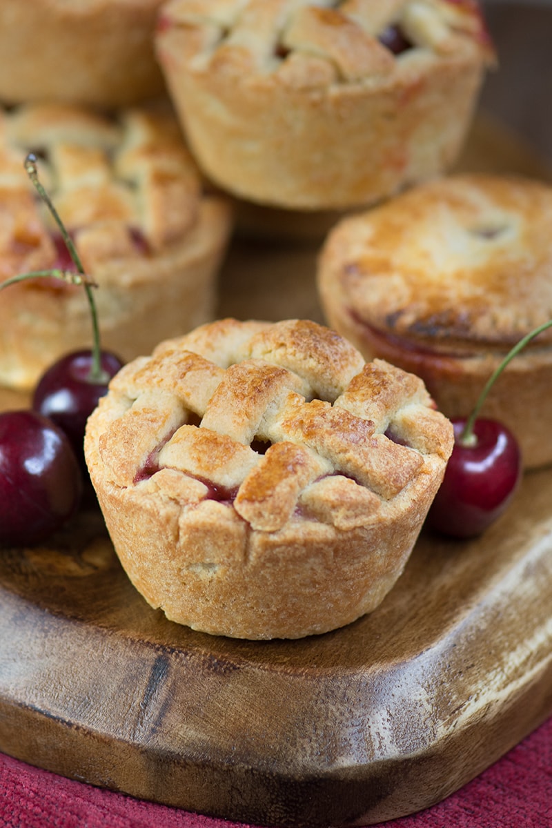 Homemade cherry pies with a pretty lattice top - crisp almond pastry, filled with juicy cherries. Perfect for a summer picnic or with a scoop of icecream for dessert.