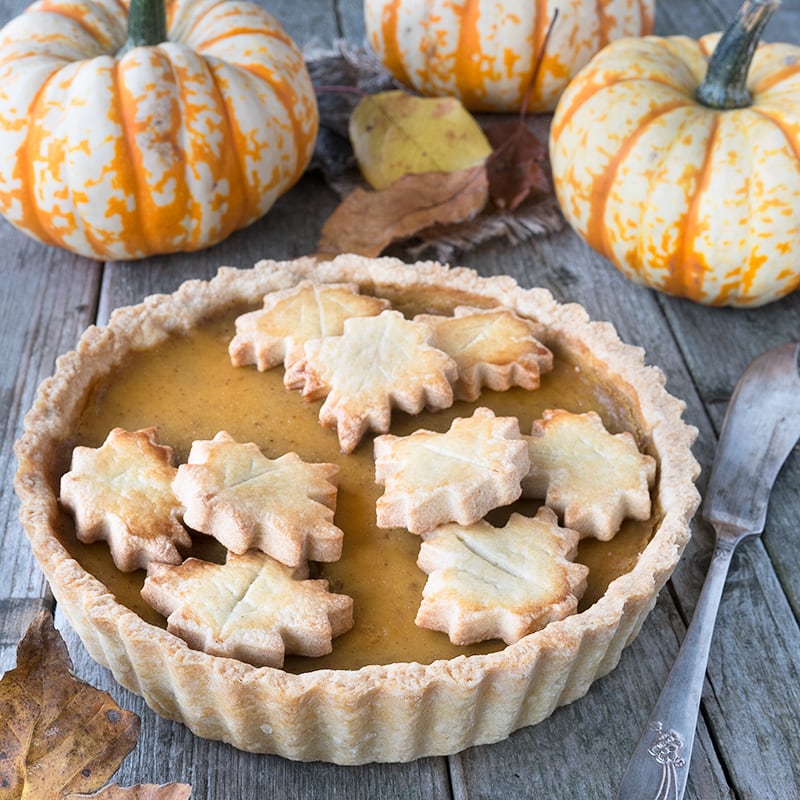 Baked whole pumpkin pie shown from the front ready to be served. 