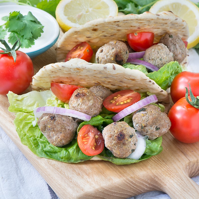 These easy lamb koftas flavoured with spices, mint and lemon zest are perfect for a summer barbecue, served in a flat bread with salad and yogurt.