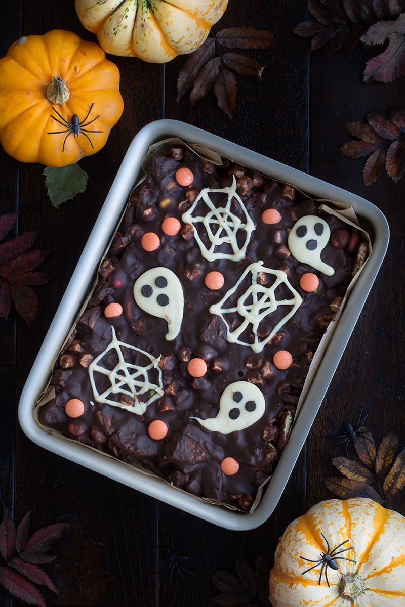 Spooky Rocky Road - a delicious and easy to make Halloween treat packed with crunchy biscuits, Smarties, marshmallows and lots of chocolate. There's an option to make it taste like Chocolate Orange too!