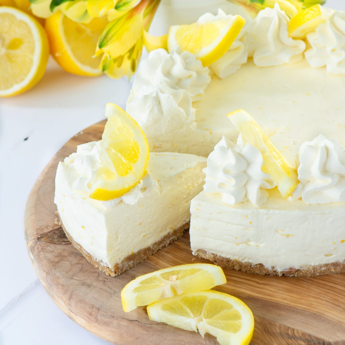 A no-bake lemon cheesecake with a slice cut out.