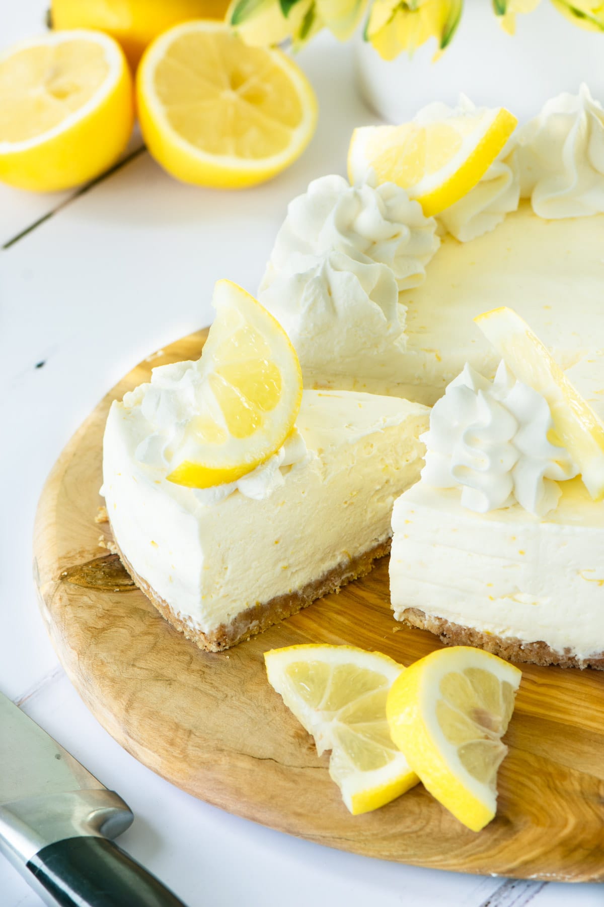 A no-bake lemon cheesecake with a slice cut out.