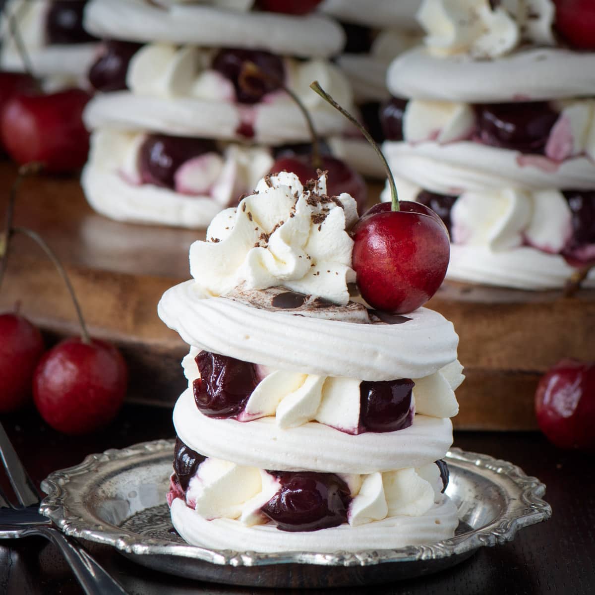 A Black Forest Meringue Stack. Three layers of meringue sandwiched with piped whipped cream and cherries.