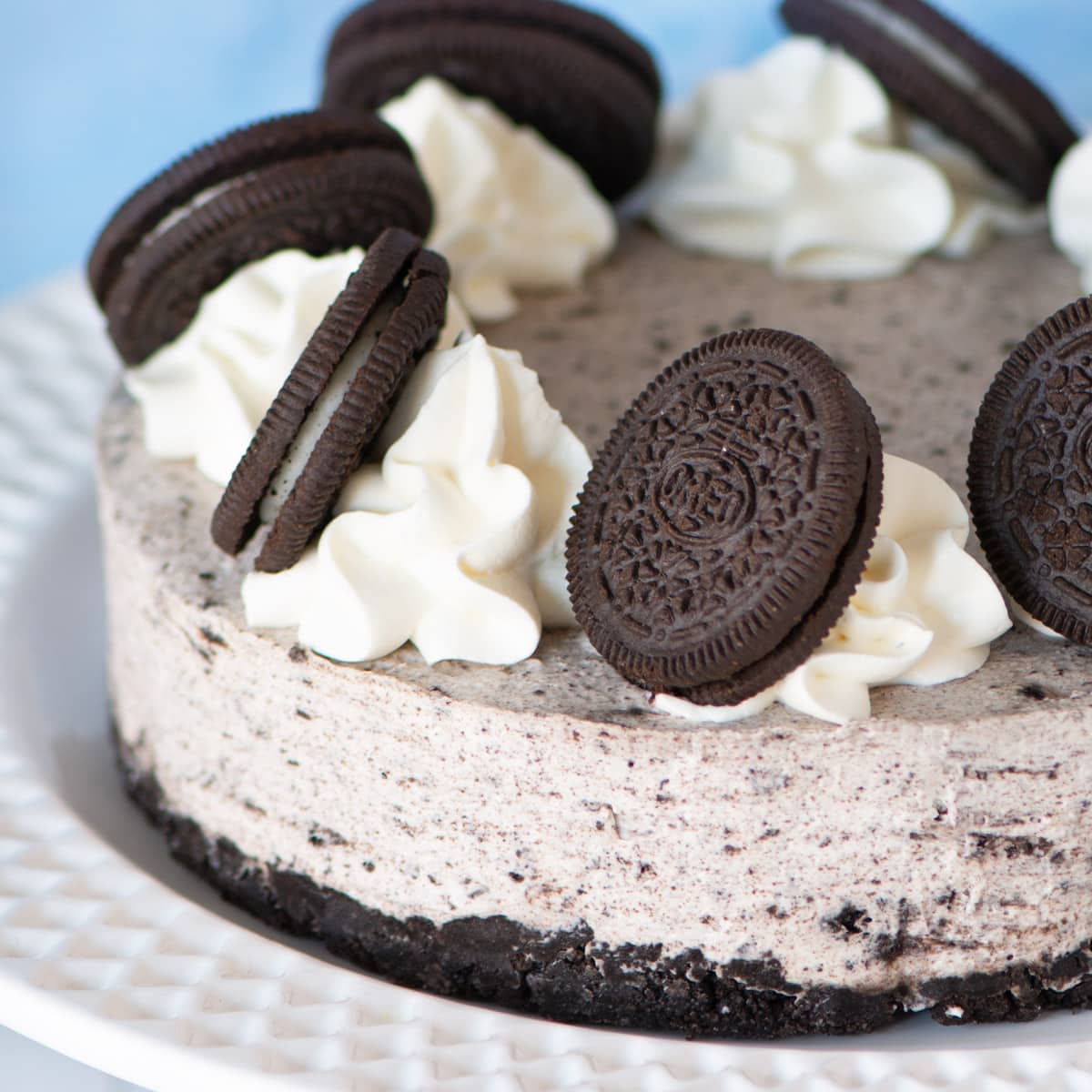 A no-bake Oreo cheesecake topped with whipped cream and Oreos.