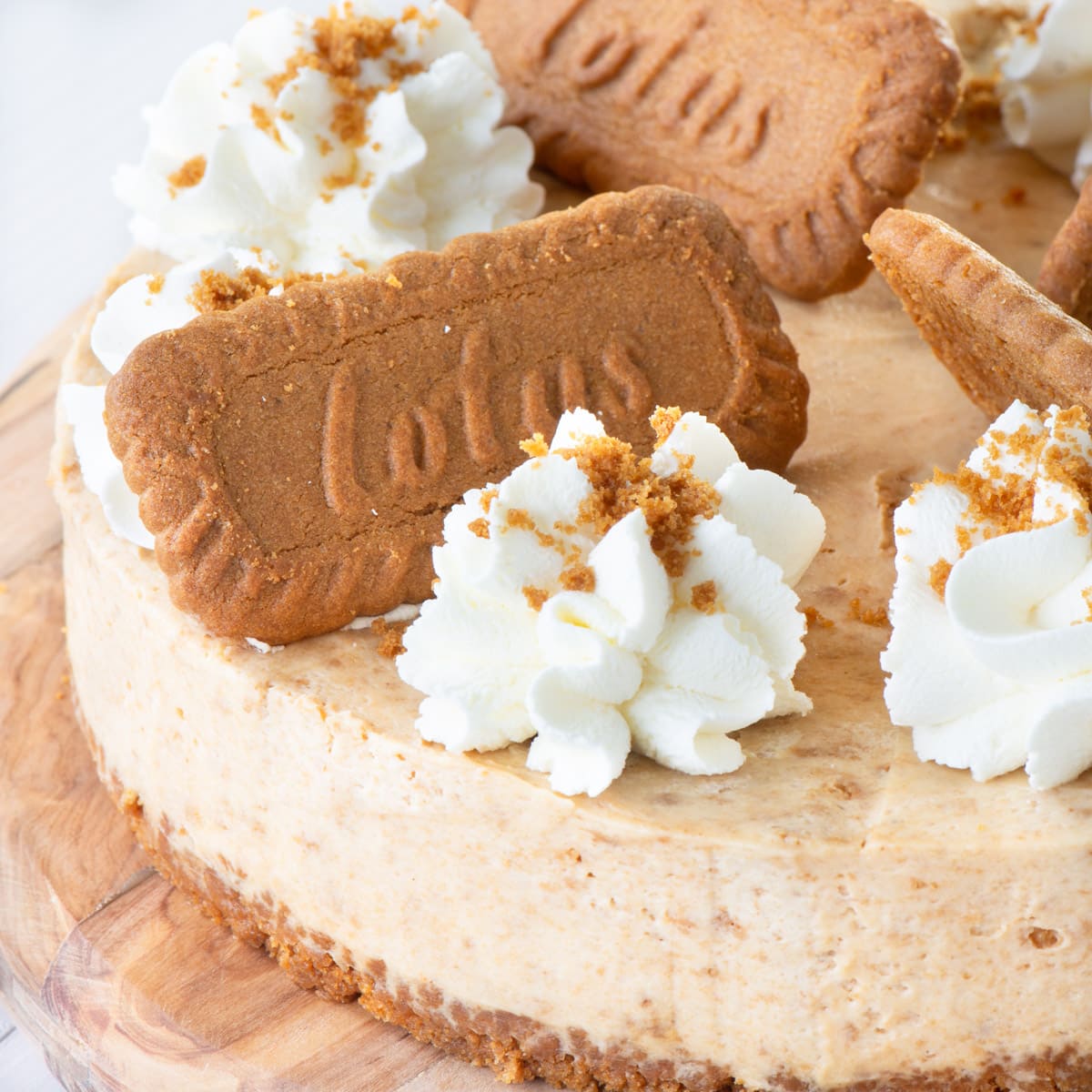 A Biscoff cheesecake on a wooden board.