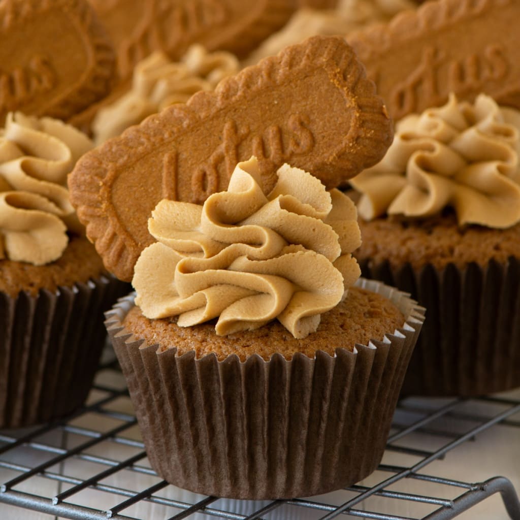 Close up of a Biscoff cupcake. The cupcakes is decorated with Biscoff buttercream, and topped with the Biscoff biscuit.