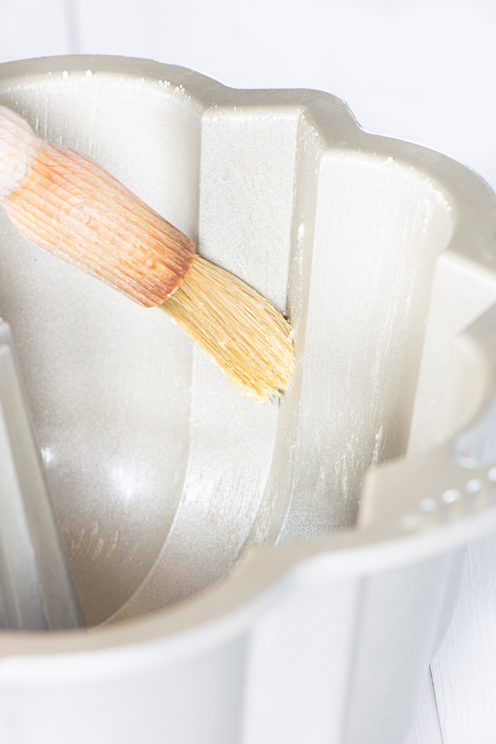 Cake release being brushed onto the inside of a bundt tin.