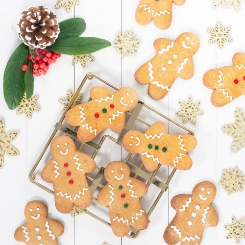 Gingerbread men decorated with royal icing on a wire rack.
