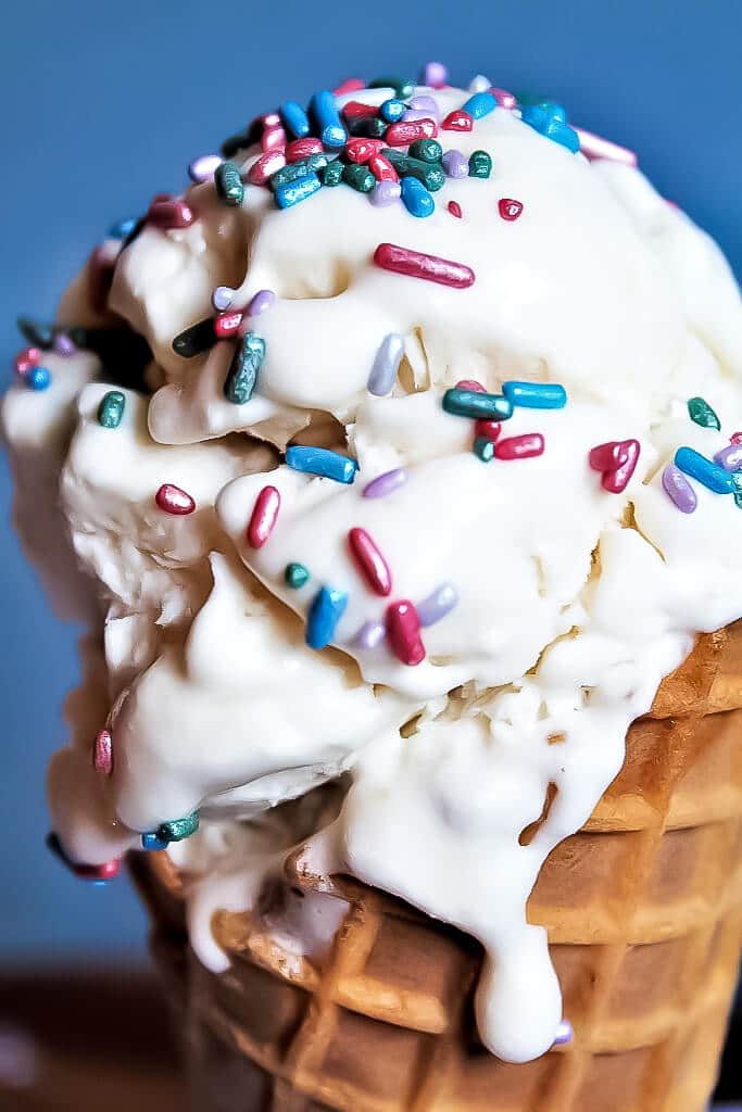 Vegan ice cream in a cone topped with sprinkles.