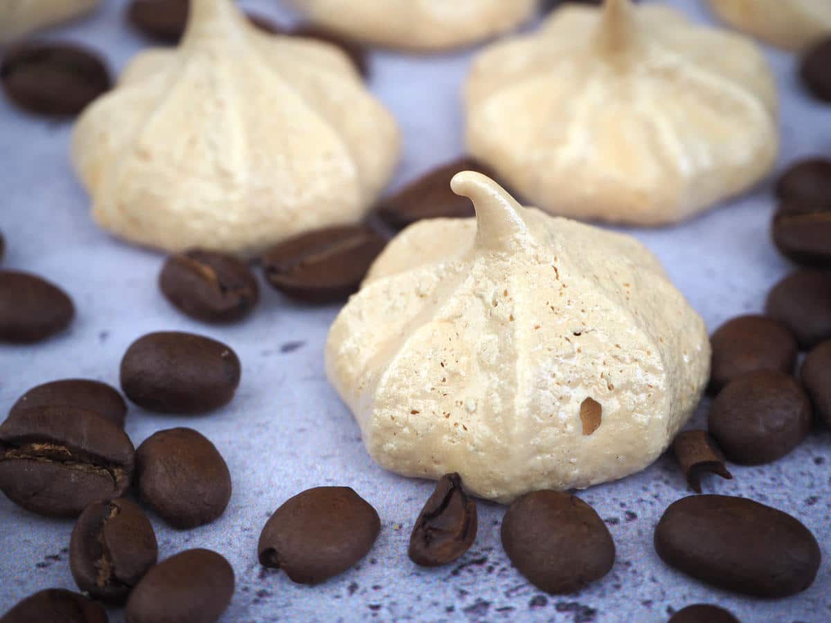 Coffee meringues surrounded by coffee beans.