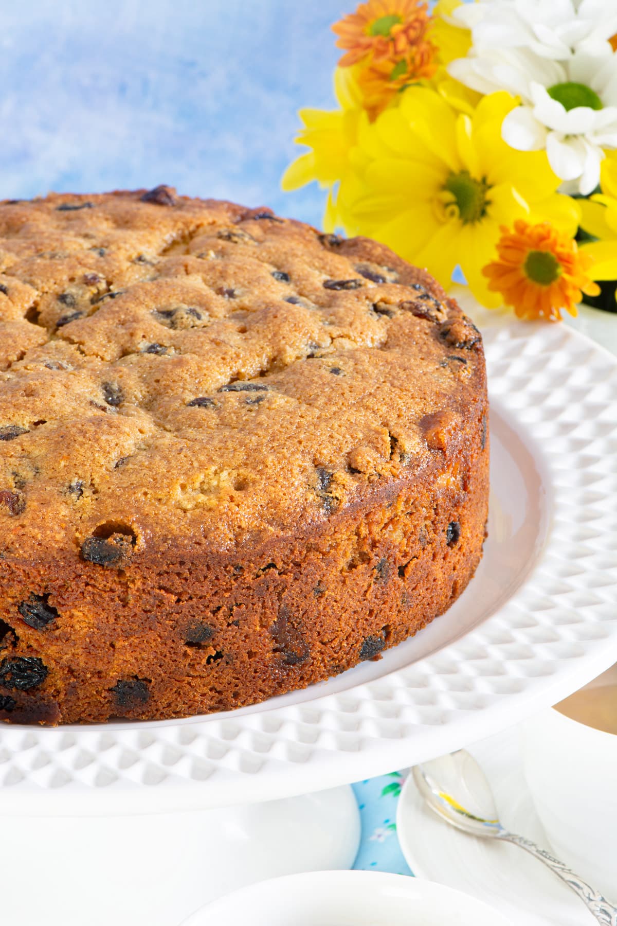 Close up of the undecorated simnel cake on a white cake stand. 