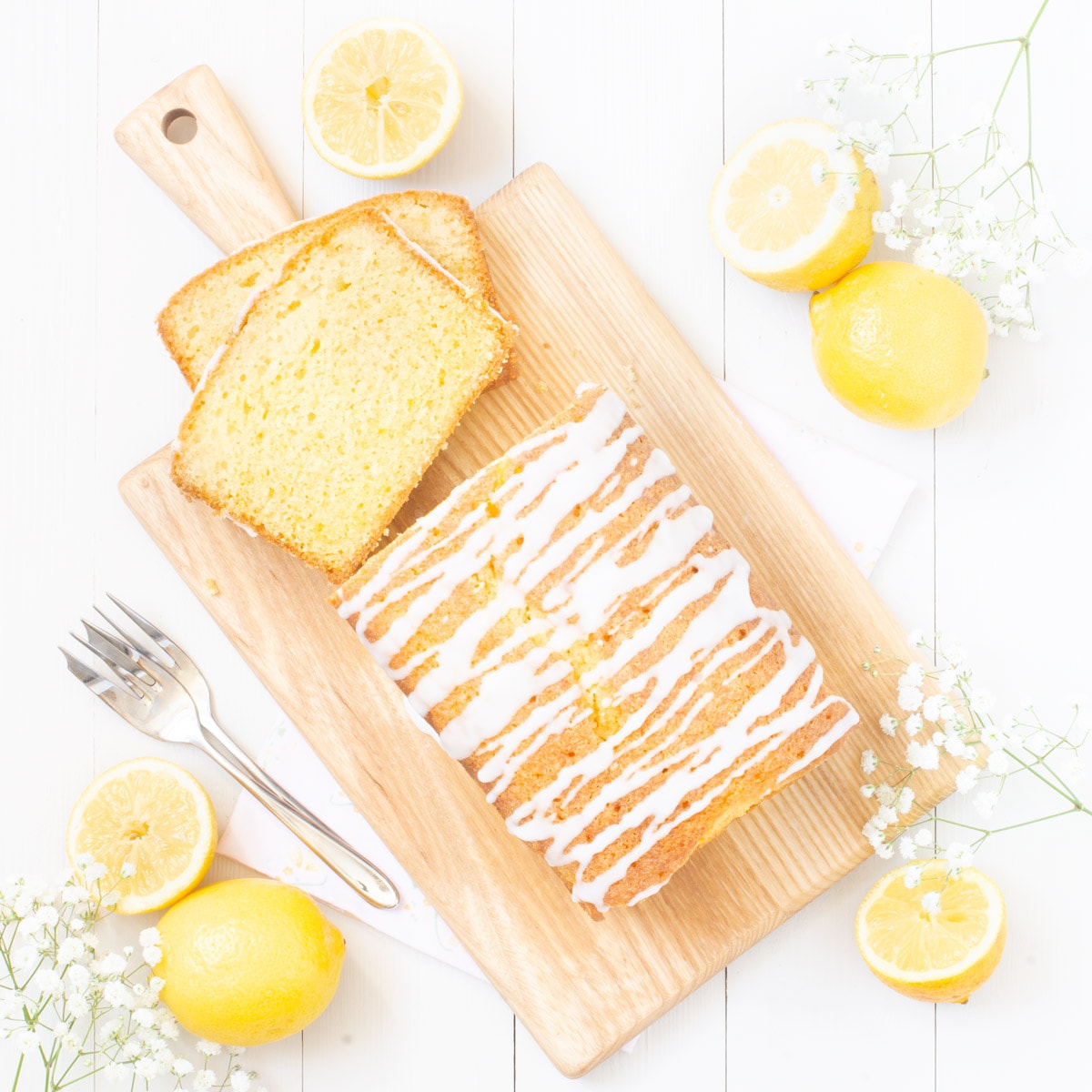 Drizzle cake on a wooden board shown from above with two slices cut so the inside crumb is seen. 