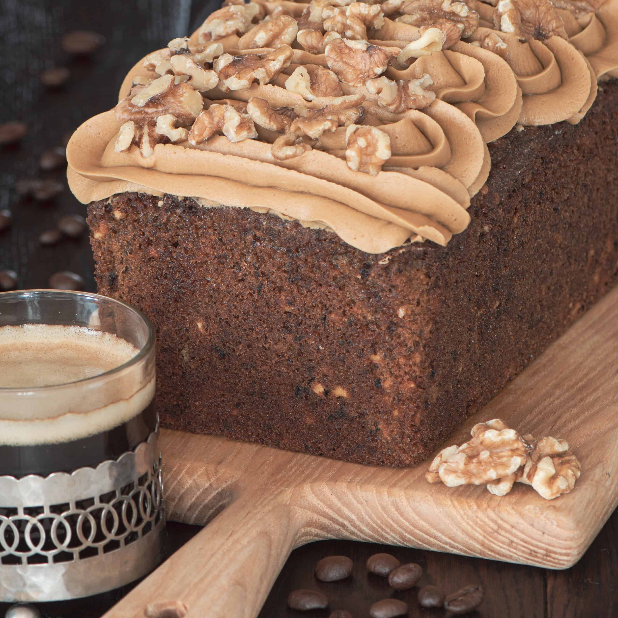 Coffee and walnut load cake topped with coffee buttercream and chopped walnuts.